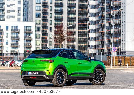 Riga, Latvia - 26 March, 2021: Green Electric Vehicle Opel Mokka-e In The Parking Lot On The Backgro