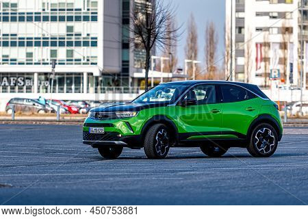 Riga, Latvia - 26 March, 2021: Green Electric Vehicle Opel Mokka-e In The Parking Lot On The Backgro