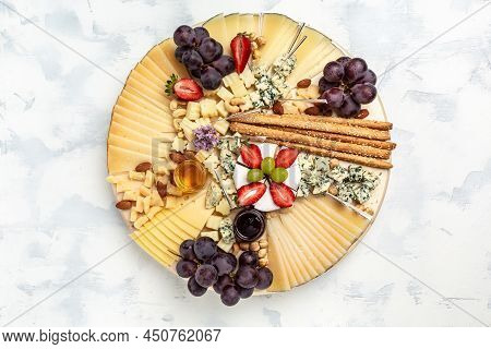 Cheese Variety Board Or Platter With Cheese Assortment, Grapes, Honey And Nuts. Aperitivo Party Conc