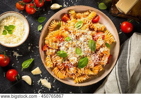 Italian Pasta Alla Arrabiata With Basil And Parmesan Cheese On Dark Table. Top View With Ingredients