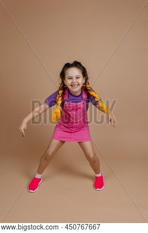 Exuberant Little Female Child With Yellow Kanekalon Braids With Legs Wide Apart Smiling Showing Piec