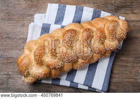 Homemade Braided Bread With Sesame Seeds On Wooden Table, Top View. Traditional Shabbat Challah