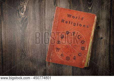 World Religions Book With Religious Symbols Printed On Wooden Table. Top View.
