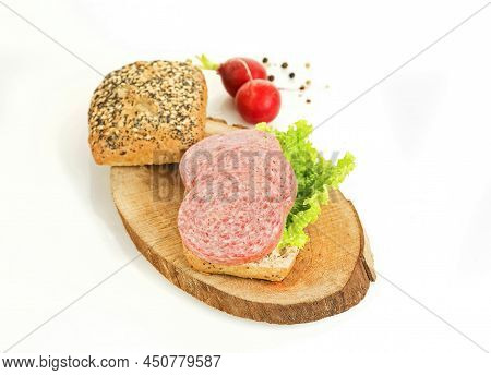 A Sandwich Of Turkey Meat Salami And Lettuce On A Wooden Board