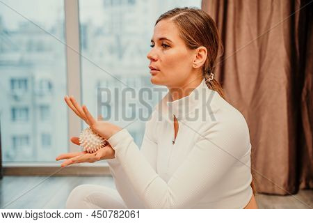 Athletic Slim Caucasian Woman Doing Thigh Self-massage With A Massage Ball Indoors. Self-isolating M