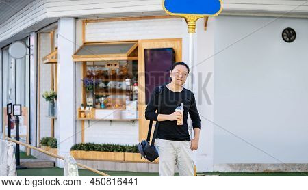 Asian Man In The Black T-shirt Holds The Bubble Ball Ice Milk Tea In Front Of The Shop On The Outdoo