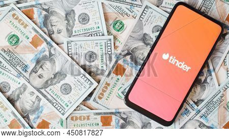 Tinder Mobile App For Romantic Dating Logo On Smartphone Screen And Money Background. Top View, Copy