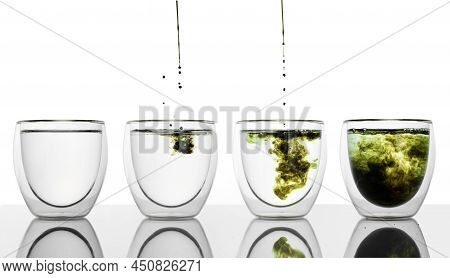 Glass Of Water With Chlorophyll Extract Against White Grey Background. Filling A Few Glasses With Li