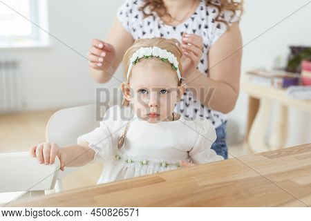 Mother Helps To Put On Cochlear Implant For Her Deaf Little Daughter. Hearing Aid And Deafness Conce