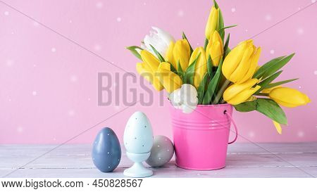 Easter Holiday Decorations: Wooden Eggs And Bouquet Of Yellow Tulips In Bucket On Pink Background. C