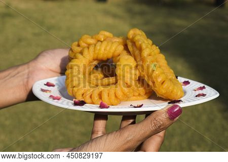 Female Holding Imarti Sweets, Popular Sweet Dish From India. Circular Spiral Shape Dessert Made With