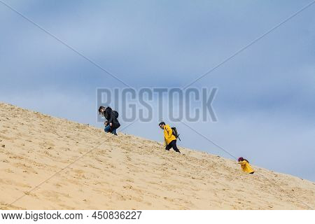 Pilat, France - February 22, 2022: Family Of Tourists, Parents With Children, Climbing The Pilat Dun