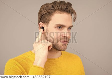 Bluetooth Headset Device Accessory. New Bluetooth Technology. Man Point Finger At Wireless Earbud