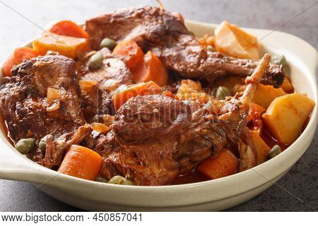Rabbit Stewed In Red Wine With Vegetables And Garlic Close-up In A Saucepan On The Table. Horizontal
