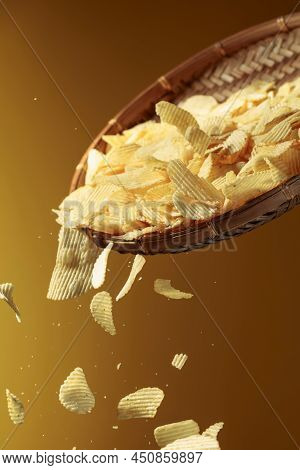 Falling Potato Chips On A Yellow Background. Copy Space.