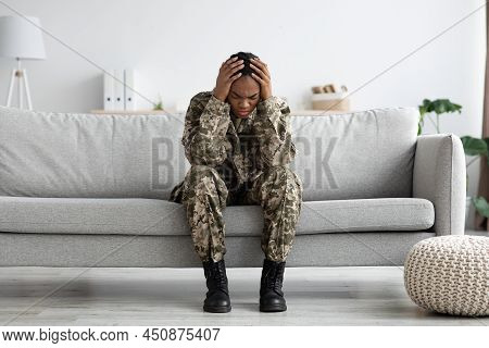 Posttraumatic Syndrome. Desperate Black Military Woman Sitting On Couch And Touching Head