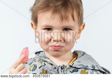 Cute Little Caucasian Boy With Blond Hair Is Holding A Pink Dental Myofunctional Trainer On White Th