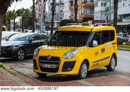 Side, Turkey -february  20, 2022:yellow Taxi Fiat Doblo    Is Parked  On The Street On A Warm Summer