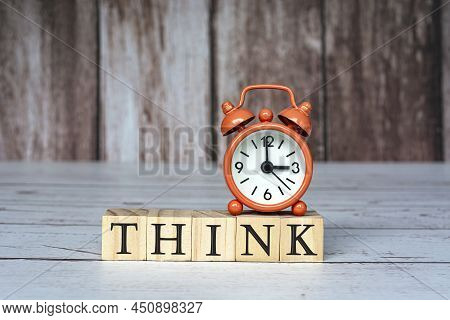 Think Text On Wooden Blocks And Alarm Clock Set At 3 O'clock On Table. Business And Idea Concept.