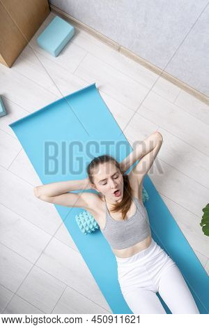 Fitness Woman With Foam Roller Under Back. Top View. Beautiful Caucasian Woman Uses Roller For Physi