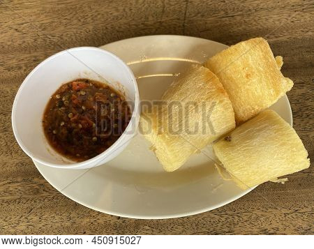 Slices Of Fried Cassava And Chili Sauce On A White Plate. Focus Selected