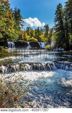 Magnificent Southern Europe, Croatia, small town Slunj. Beautiful sunny day. Scenic waterfall cascades on the river Sluncica. The concept of ecological, active and photo tourism