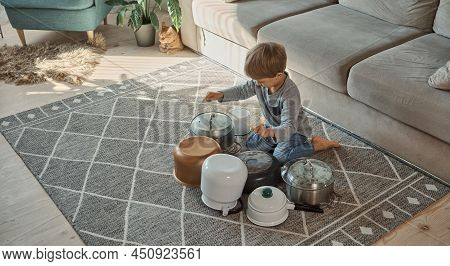 Child Drummer Having Fun Drum Playing On Kitchen Pans At Home