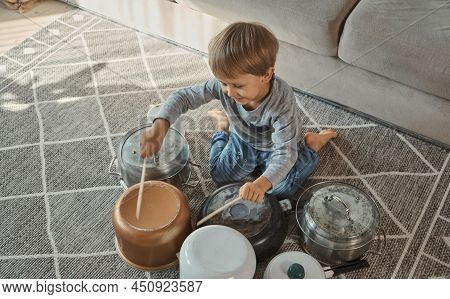 Child Drummer Having Fun Drum Playing On Kitchen Pans At Home
