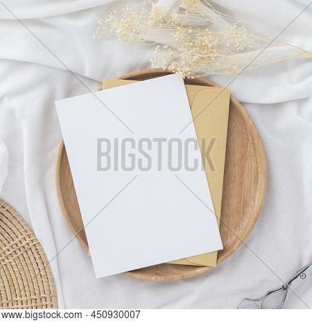 Blank Greeting Card Invitation Mockup 5x7 On Brown Envelope With Dried Flowers On Pastel Green Backg