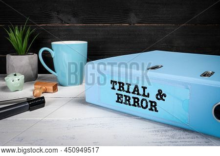 Trial And Error. Document Binder And Office Supplies On A Wooden Office Desk