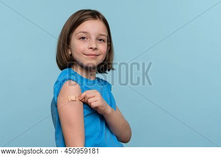 Child Vaccinated. Cute Little Girl Pointing Finger At Adhesive Plaster Bandage On Her Arm After Bein