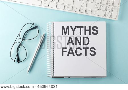 Keyboard, Notebook,pen And Glasses On Blue Background , Text Myths And Facts