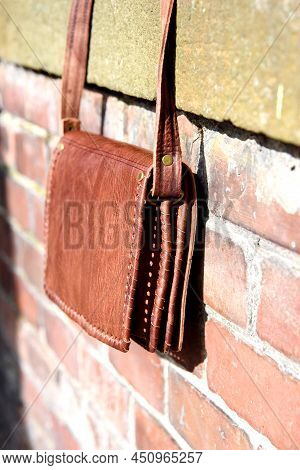 Close-up Photo Of Orange Leather Messanger Bag. Outdoors Photo