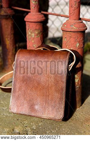 Close-up Photo Of Orange Leather Messanger Bag. Outdoors Photo