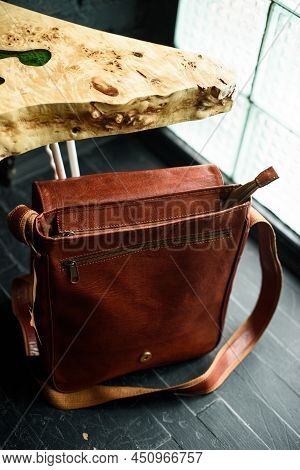 Close-up Photo Of Orange Leather Messanger Bag On A Wooden Table