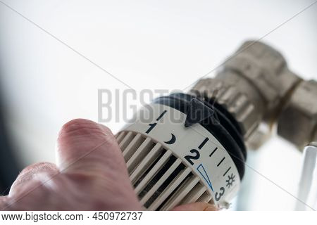 Close-up Of Hand Turning Thermostat Down. Turn Heating Off. Gas Price. Savings. High Quality Photo