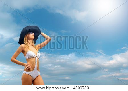Kvinde i bikini iført en hat af havet