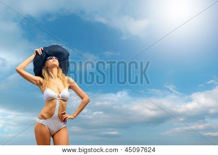 Kvinde i bikini iført en hat af havet