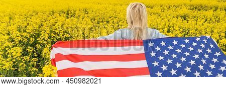 Adult Woman Holding American Flag With Pole, Stars And Stripe In A Yellow Rapeseed Field. Usa Flag F