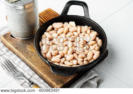 White Canned Beans Set, With Metal Can, In Cast Iron Frying Pan, On White Stone  Surface