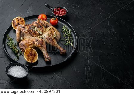 Spatchcocked Poussins, With Chimichurri Sauce, On Black Background With Copy Space For Text