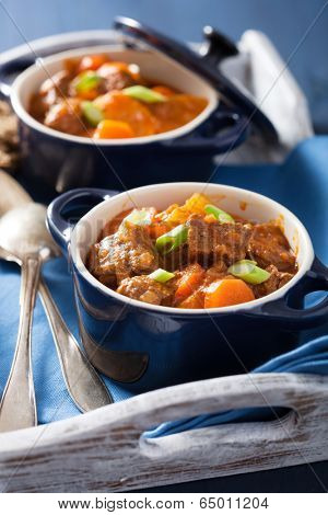beef stew with potato and carrot in blue pots 