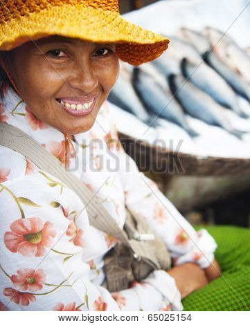 Indigenous cambodian woman selling fish in a market.