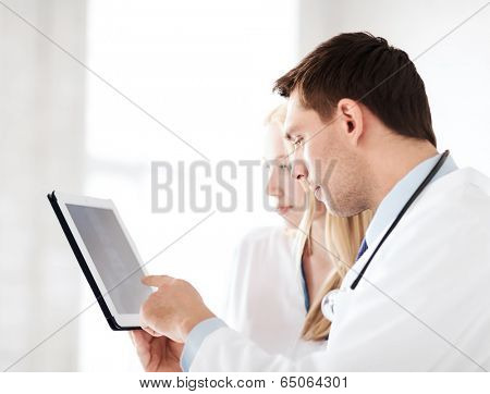 healthcare and medical - two doctors looking at x-ray on tablet pc