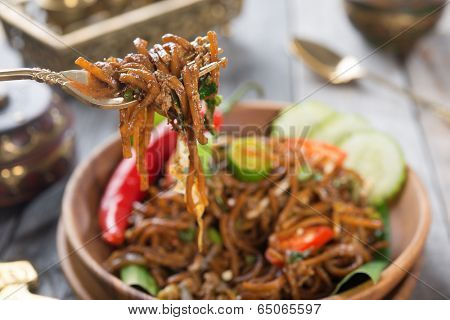 Delicious Asian spicy fried noodles, ready to serve on dining table.