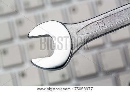 a wrench as a tool on a computer keyboard. symbol photo for privacy, online crime, and security on the internet
