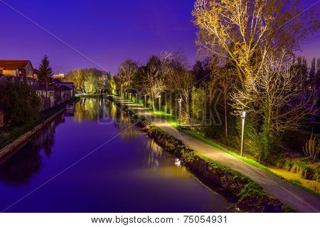 A Night in the Park. Late Spring Night in the Park. River and Park Alley. Horizontal Photography. Central Europe. France. Paris. Amiens.