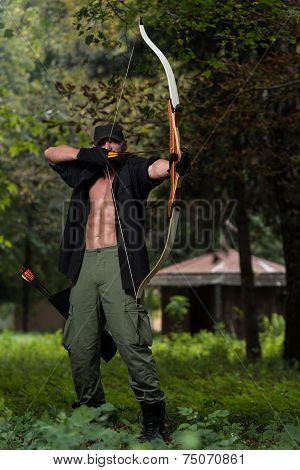 Man With A Bow And Arrows In Woods