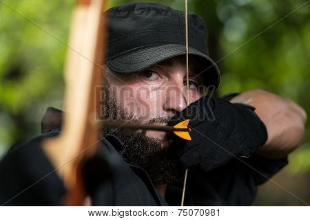 Archer Holds His Bow Aiming At A Target