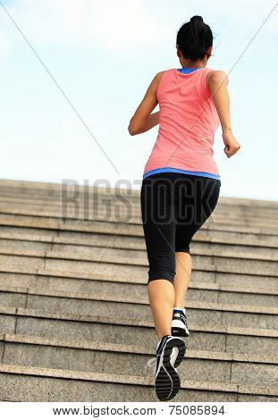 Runner athlete running on stairs. woman fitness jogging workout wellness concept.